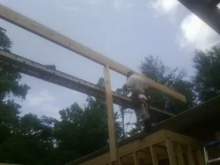 Carpenter setting a ridge beam over a new addition frame — Ice Dam Removal by Roofing Brothers in Middleburg